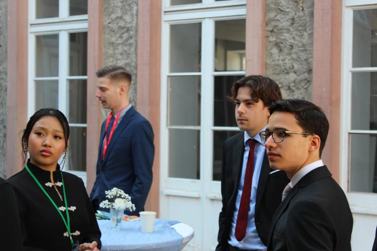 Delegates at a standing table in the historic courtyard of the campus
